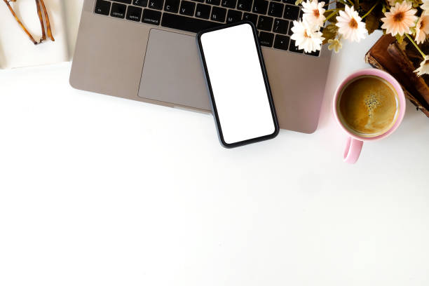 istock Office white desktop with laptop and blank screen mobile phone. workspace and copy space. 1041492916