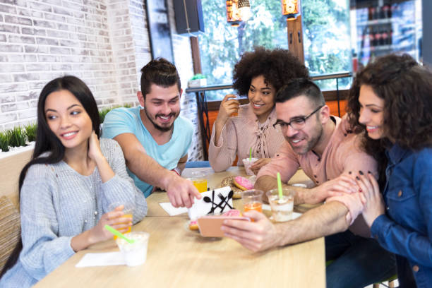 istock Multi-ethnic group of friends social networking in cafe 1041493032