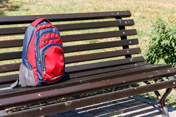 istock Backpack on wooden bench in city park 1041504470