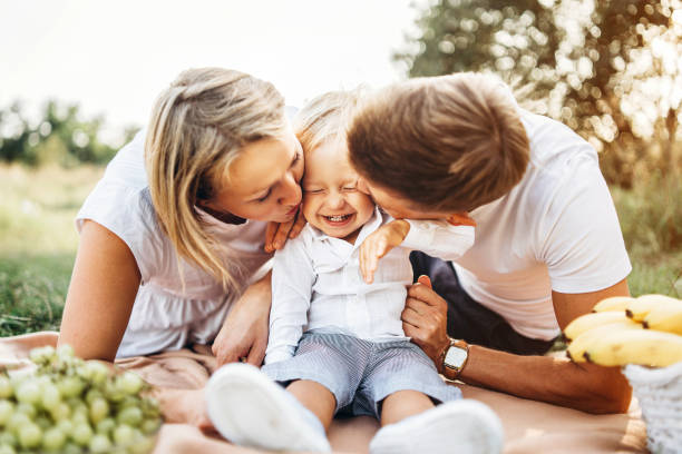Young parents with little baby boy on picnic outdoor stock photo