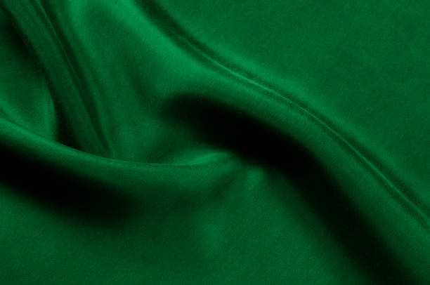 istock Background texture, pattern. Thick thick silk fabric is green. This satin fabric is ideal for creating a smooth flow in design, it has a liquid drape and exquisite shine. 1041508918