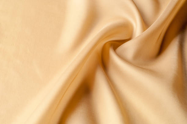 istock Texture background of fabric. Beige fabric. Silk fabric wallpaper texture background pattern in sepia pastel yellow cream beige tint: Lovely natural silk textured textile 1041508932