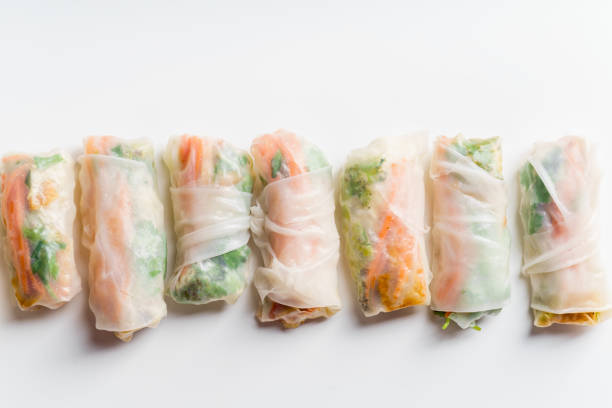 istock Vegetarian spring rolls with tofu, marinated carrot and daikon and cilantro on white background with copy space 1041513942