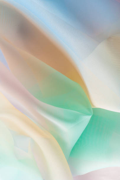 istock Texture, background, pattern. Silk fabric is transparent, yellow-pink green in blue. Abstract soft chiffon texture background. 1041514264