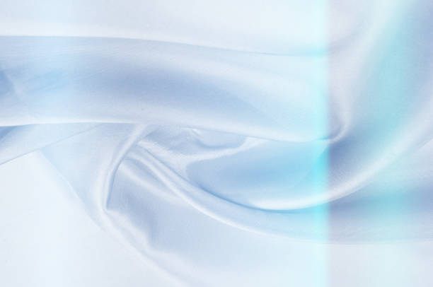 istock Background pattern, texture. Silk fabric of blue tones. Fine silk - top view - close-up of a thin silk surface shadow color serenity - pastel tone. Blue wrinkled fabric tissue background 1041514314