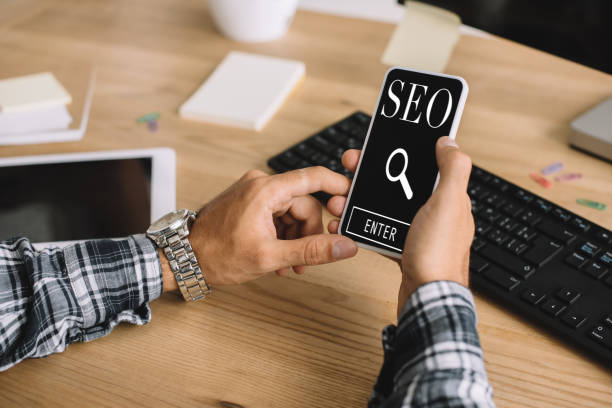 istock cropped shot of developer using smartphone with SEO sign at workplace 1041520154