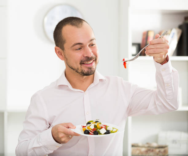 istock Smiling man looking at greek salad 1041531684