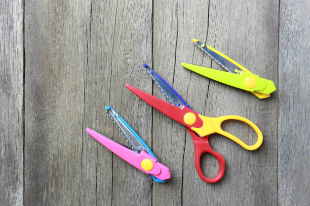istock Plastic scissors Lay on a brown wood floor background. 1041544314