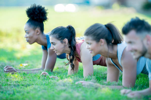 istock Diverse group of adults doing planks in the grass 1041548518