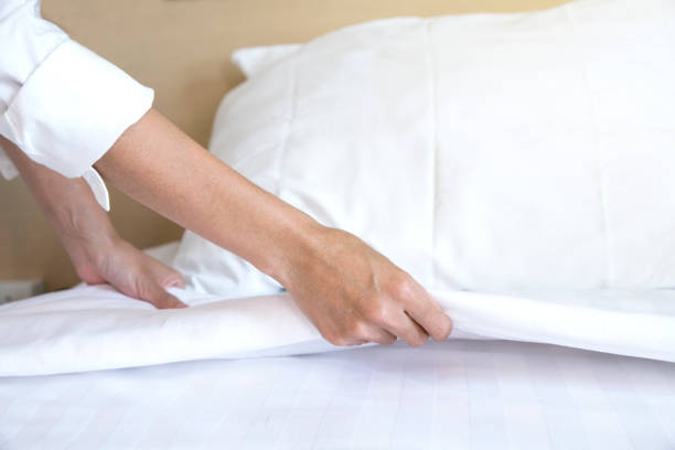 istock Close up hand set up white bed sheet in hotel room 1041567638
