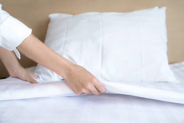istock Close up hand set up white bed sheet in hotel room 1041569700