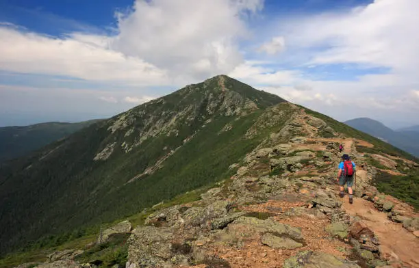 Photo of Hiker trekking along Franconia mountain ridge traverse, with a beautiful landscape background. Mount Lafayette, Mount Lincoln