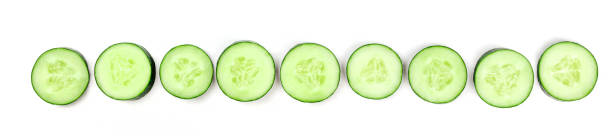 istock Cucumber slices forming a line on a white background with a place for text 1041579756