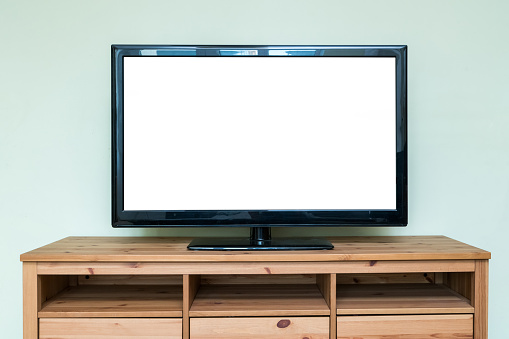 Flat LCD television on brown wooden cabinet in the living room with a white screen for copy text