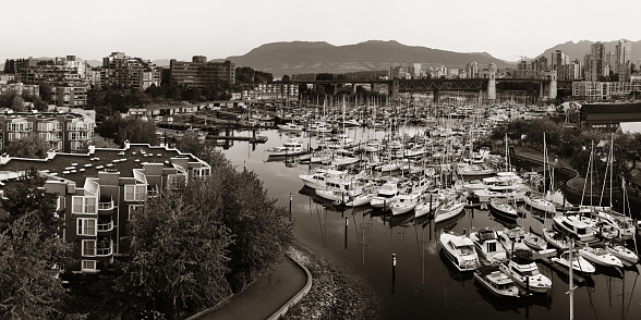 Vancouver harbor view with urban apartment buildings and bay boat in Canada.