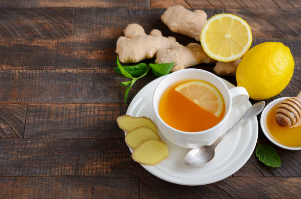 istock Ginger root tea with lemon and honey on wooden table. 1041630744