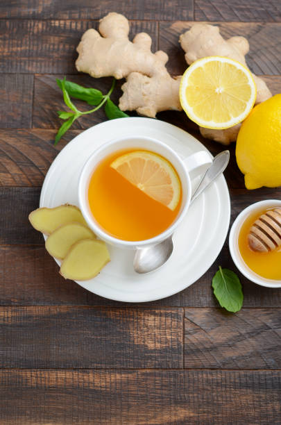 istock Ginger root tea with lemon and honey on wooden table. 1041630750