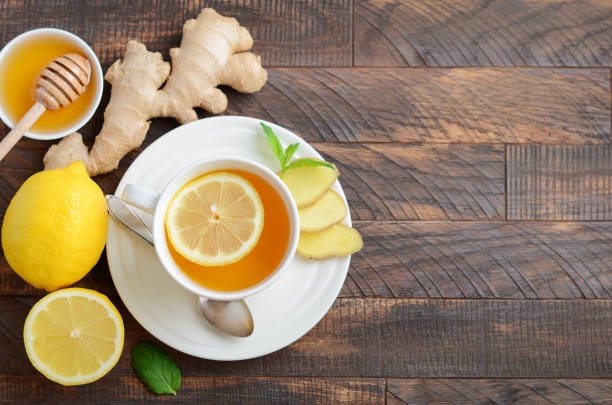 istock Ginger root tea with lemon and honey on wooden table. 1041630762