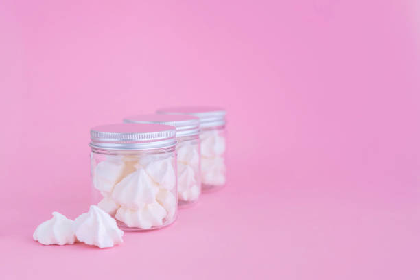 istock White meringues in small glass containers on pink background. 1041637590