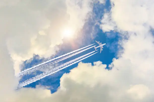 Airplane flies high in the sky, a journey through the clouds and a sunny glare
