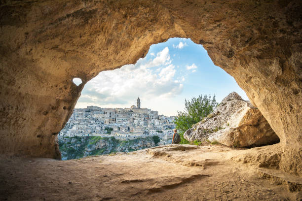Woman walking in a cave of Matera, Basilicata, Italy Matera (The City of Stones), European Capitals of Culture 2019 matera stock pictures, royalty-free photos & images