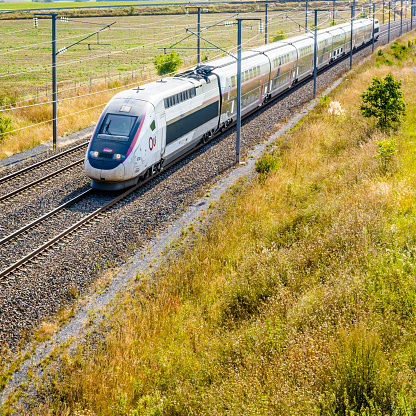 Varreddes, France - August 18, 2018: A TGV Duplex high speed train in Carmillon livery from french company SNCF driving on the LGV Est, the East European high speed railway line, in the countryside.
