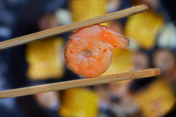 Fried shrimp between chopsticks. The concept of East Asian food.