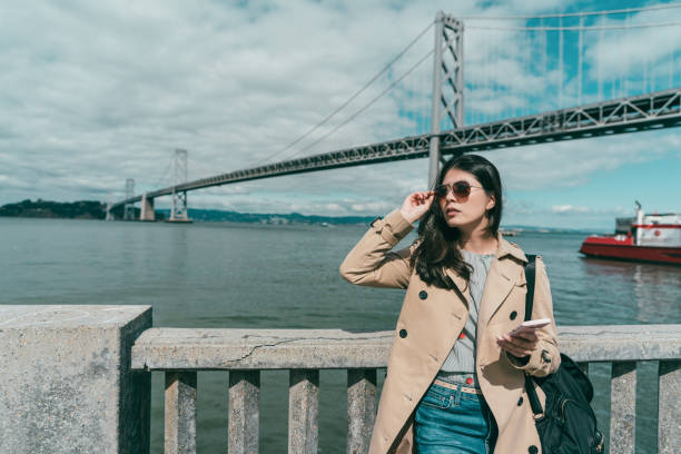 istock woman holding sunglasses while looking somewhere 1041657880