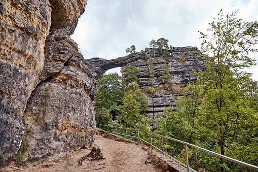 pathway and railing between beautiful pravcicka brana rock formation in Czech Republic