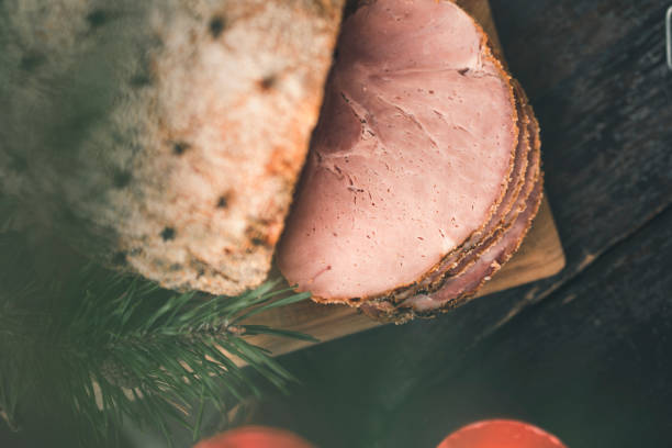 A traditional Swedish Christmas buffet dinner on a dark wooden table, decorated with pine needles, pine cones and candles.