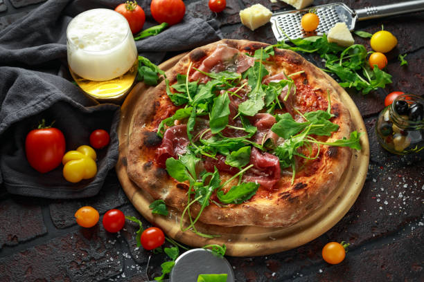 istock Stone Baked Pizza with prosciutto ham, arugula, parmesan and mozzarella cheese, beer 1041691834