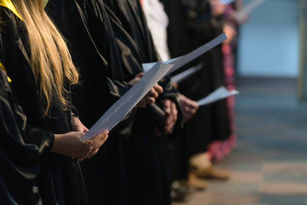 cantanti del coro che tengono partitura musicale e cantano il giorno della laurea all'università, inizio del diploma universitario - chorus foto e immagini stock