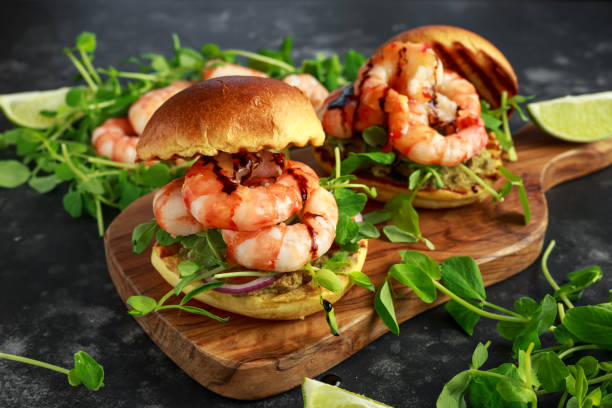 zdrowe smaczne krewetki grillowane burger z pędów grochu i słodkie chilli dip podawane na drewnianej desce z klinami limonki - prepared shrimp prawn grilled lime zdjęcia i obrazy z banku zdjęć