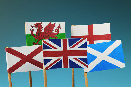 A United kingdom flag and their members as Scotland, England, Nothern Ireland, Wales. Blue and dark background