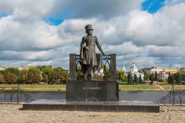 Monument to Russian poet Alexander Pushkin on the embankment in Tver, Russia. Volga river embankment. Autumn day. Picturesque landscape. Church of the Resurrection on the opposite Bank.