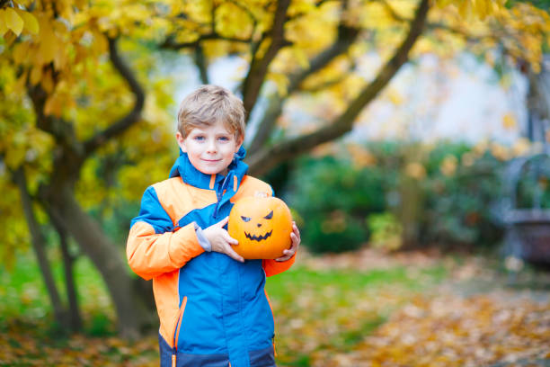 istock happy cute little kid boy with halloween pumpkin lantern on autumn 1041713708