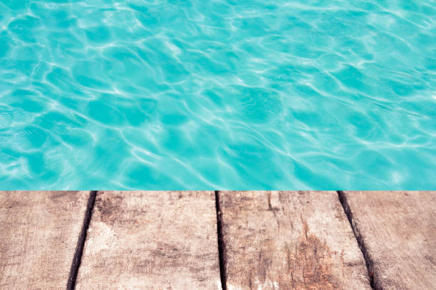 istock swimming pool with sunny reflections and wood floor 1041713936