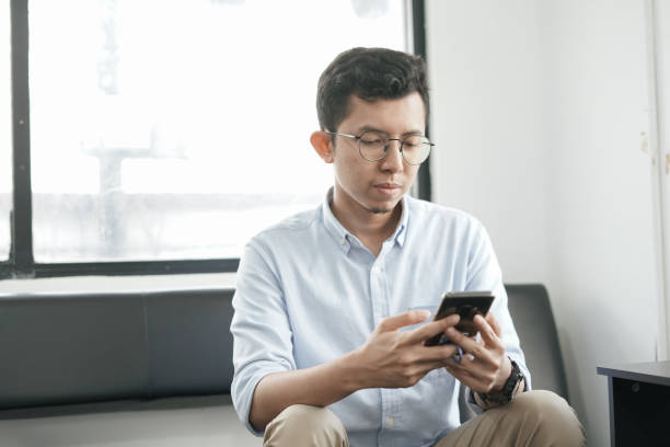 istock Young Asian Man Playing Smartphone 1041722450