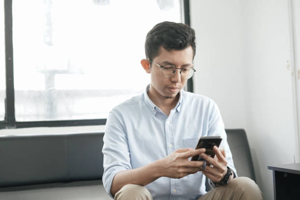 istock Young Asian Man Playing Smartphone 1041722458