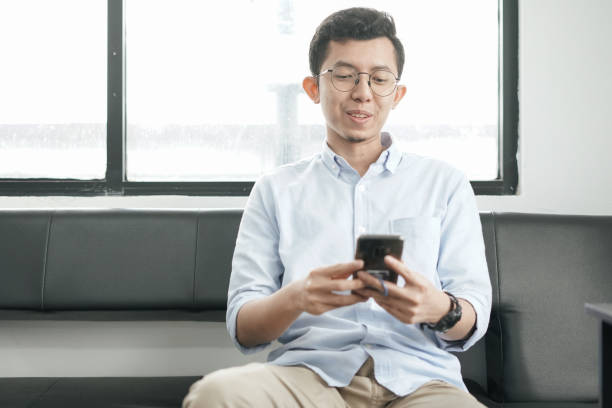 istock Young Asian Man Playing Smartphone 1041722838