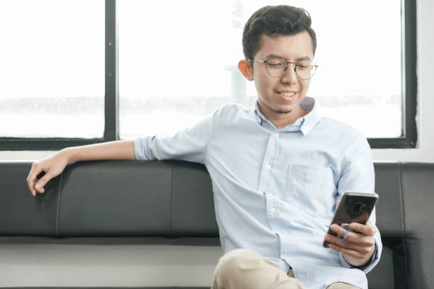 istock Young Asian Man Playing Smartphone 1041722930