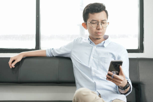 istock Young Asian Man Playing Smartphone 1041722944