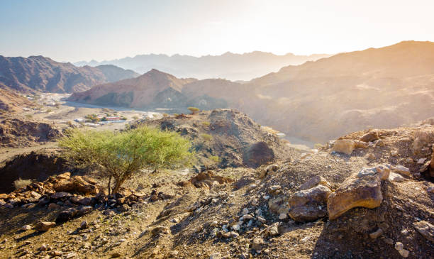 Al Hajar Mountains of Fujairah Scenic overlook of Al Hajar mountains in the emirate of Fujeirah, UAE and a village in a valley fujairah stock pictures, royalty-free photos & images