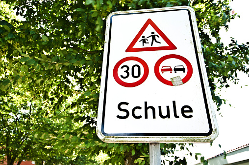 Germany, Berlin, January 17, 2024 - Speed limit traffic sign against trees and sky, Berlin Zehlendorf