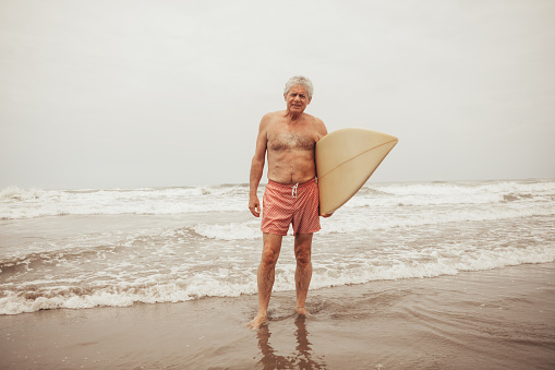 Senior man surfing