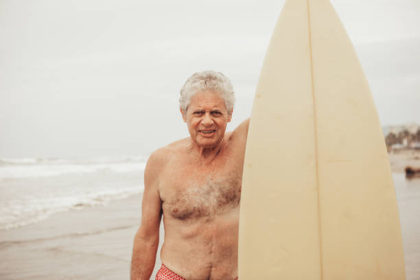 uomo anziano che naviga - senior adult surfing aging process sport foto e immagini stock