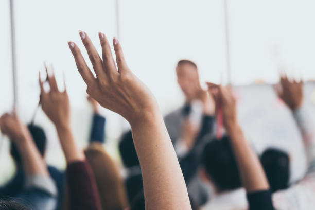 publikum hob die hände während der geschäftsmann spricht sich in der ausbildung im büro. - business training learning leadership stock-fotos und bilder