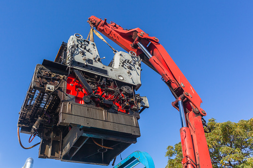 Rigging truck transpatation lifting heavy printing machine with hydraulic oil power mechanical crane arm.