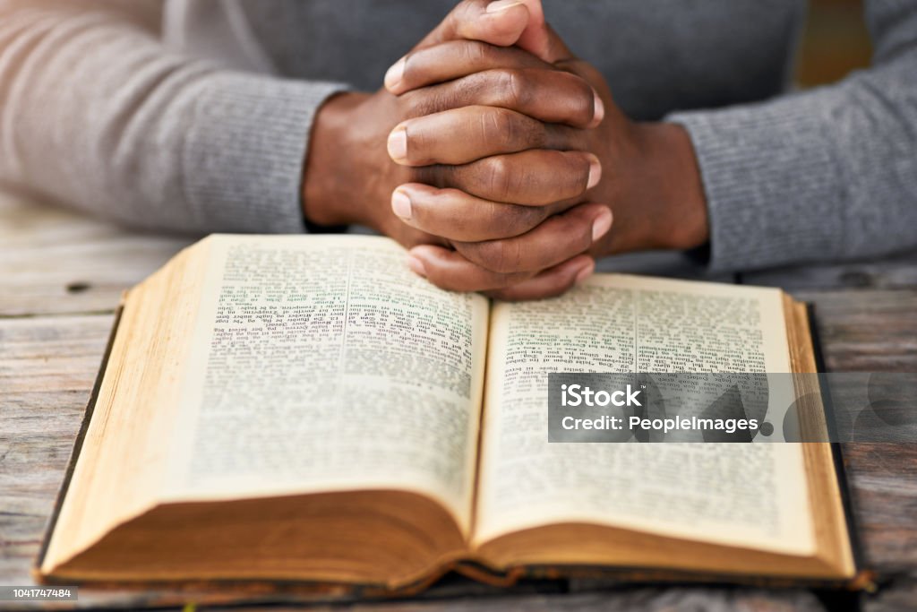 Meditating on God's word High angle shot of an unrecognizable man reading his bible while sitting outside Bible Stock Photo