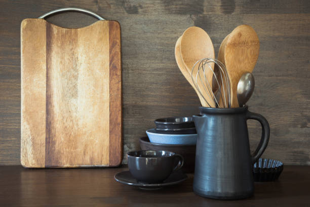 Crockery, clayware, dark utensils and other different stuff on wooden tabletop. Kitchen still life as background for design. Copy space.